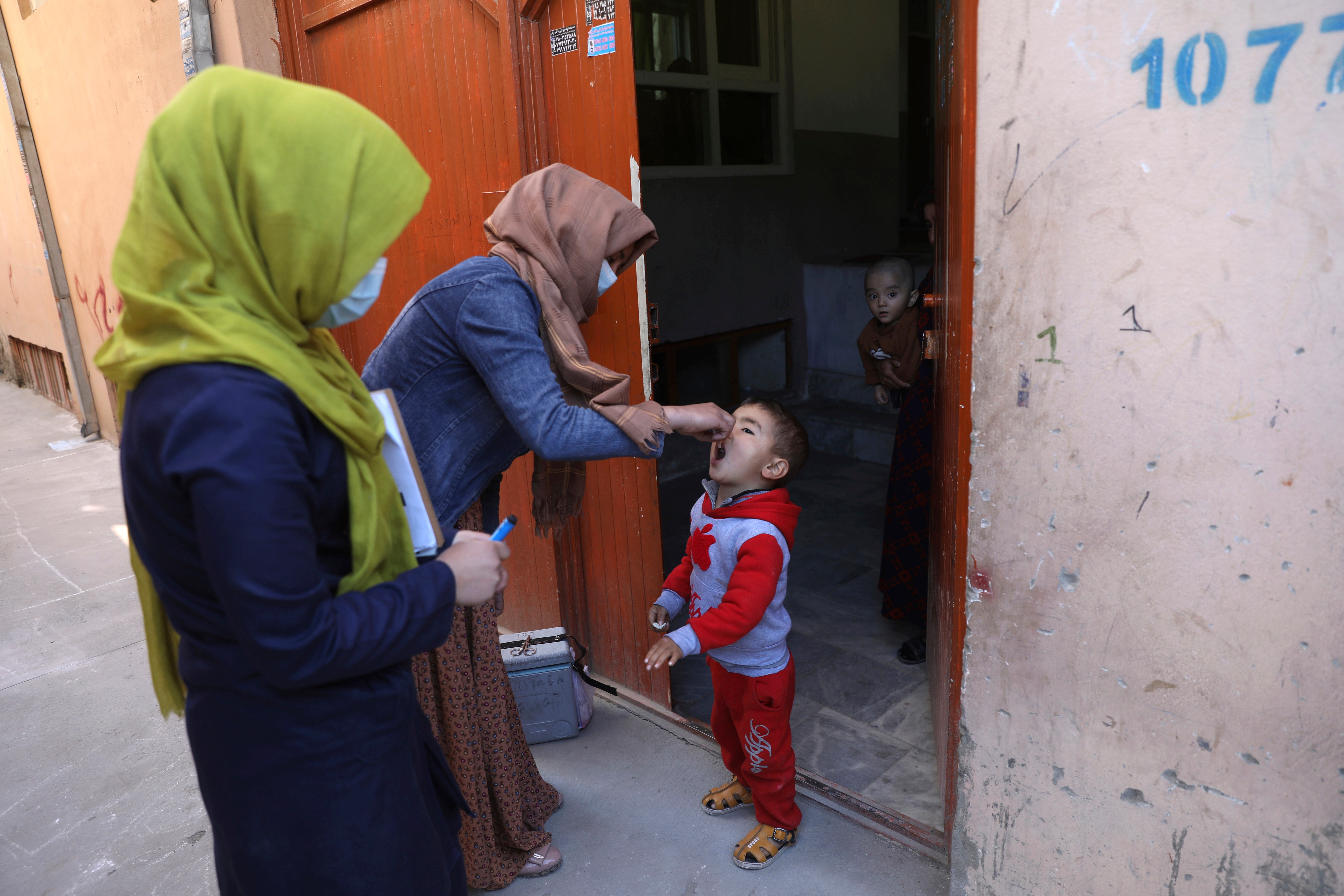 Health workers administer a polio vaccine to a child during a health campaign in the Afghan capital, Kabul