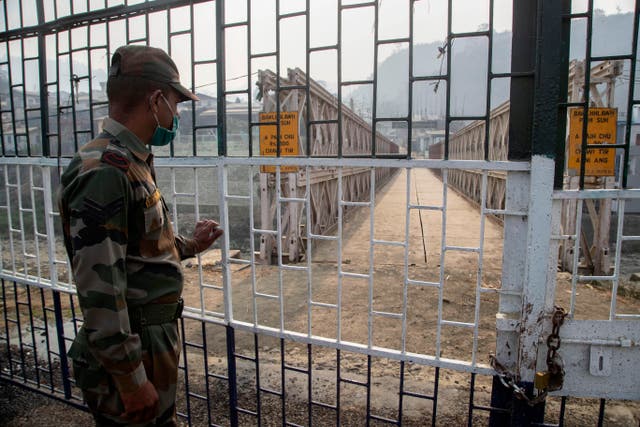 <p>An Indian paramilitary soldier stands guard near the bridge on Tiau river along India-Myanmar border in Mizoram on 20 March, 2021</p>