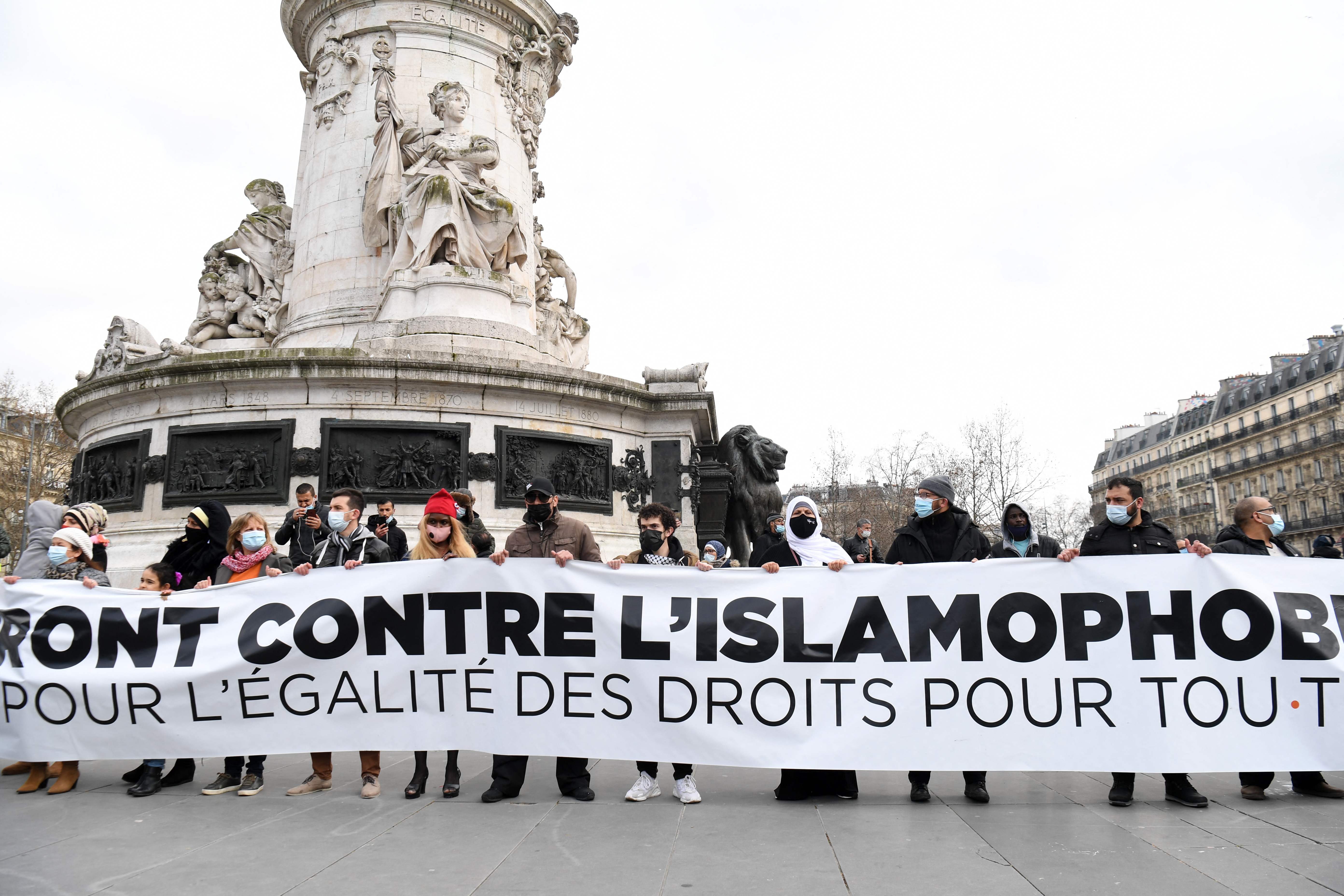 Protesters hold a banner during a demonstration against a bill dubbed as ‘anti-separatism’ and Islamophobia