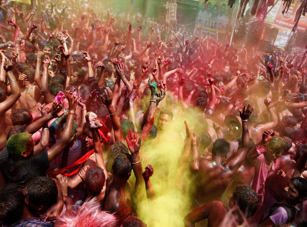 <p>Indian revelers, faces smeared with colored powder, dance during celebrations to mark Holi, the Hindu festival of colors in Prayagraj, India, despite a surge in the virus </p>