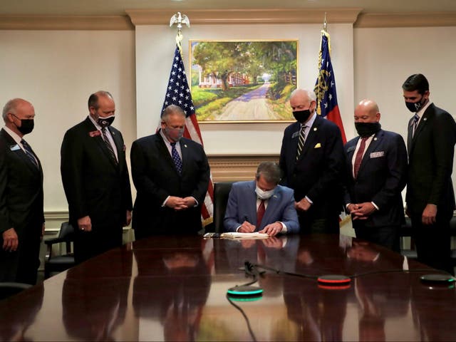 Republican Governor Brian Kemp signs the law S.B. 202, a restrictive voting law that activists have said aimed to curtail the influence of Black voters who were instrumental in state elections that helped Democrats win the White House and narrow control of the U.S. Senate, in this handout photo posted to Kemp's Twitter feed on March 25, 2021. Governor Brian Kemp's Twitter feed/Handout via REUTERS  THIS IMAGE HAS BEEN SUPPLIED BY A THIRD PARTY.