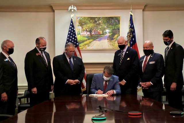 Republican Governor Brian Kemp signs the law S.B. 202, a restrictive voting law that activists have said aimed to curtail the influence of Black voters who were instrumental in state elections that helped Democrats win the White House and narrow control of the U.S. Senate, in this handout photo posted to Kemp's Twitter feed on March 25, 2021. Governor Brian Kemp's Twitter feed/Handout via REUTERS  THIS IMAGE HAS BEEN SUPPLIED BY A THIRD PARTY.
