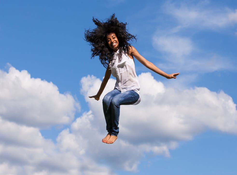 Woman jumping for joy against a blue sky backdrop