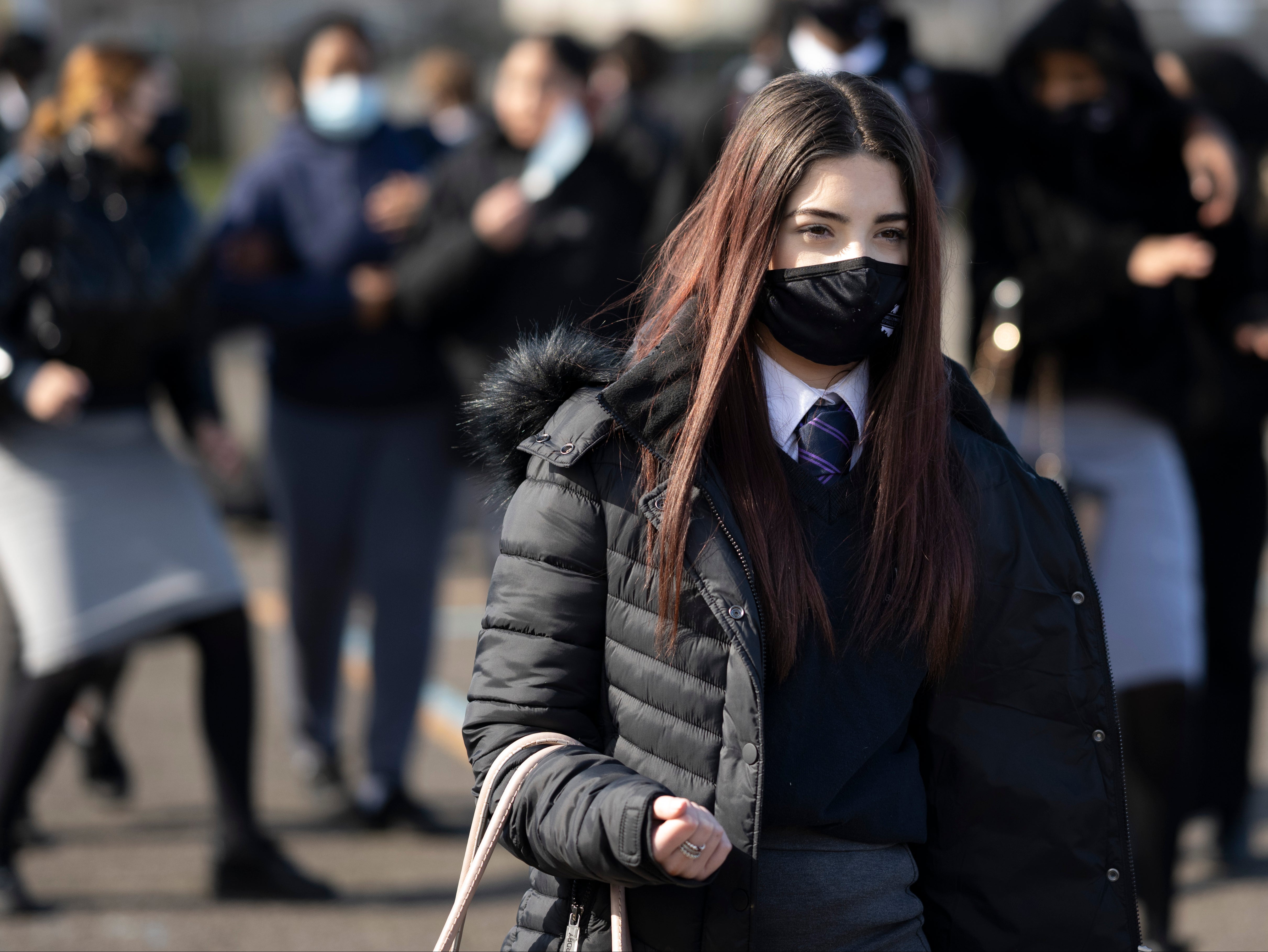 <p>Una colegiala con una mascarilla deja una lección en Willows High School el 16 de marzo de 2021 en Cardiff, Gales. Las escuelas secundarias en Gales reabrieron esta semana después de haber estado cerradas para la mayoría de los alumnos desde el comienzo del año debido a las preocupaciones de Covid-19. </p>
