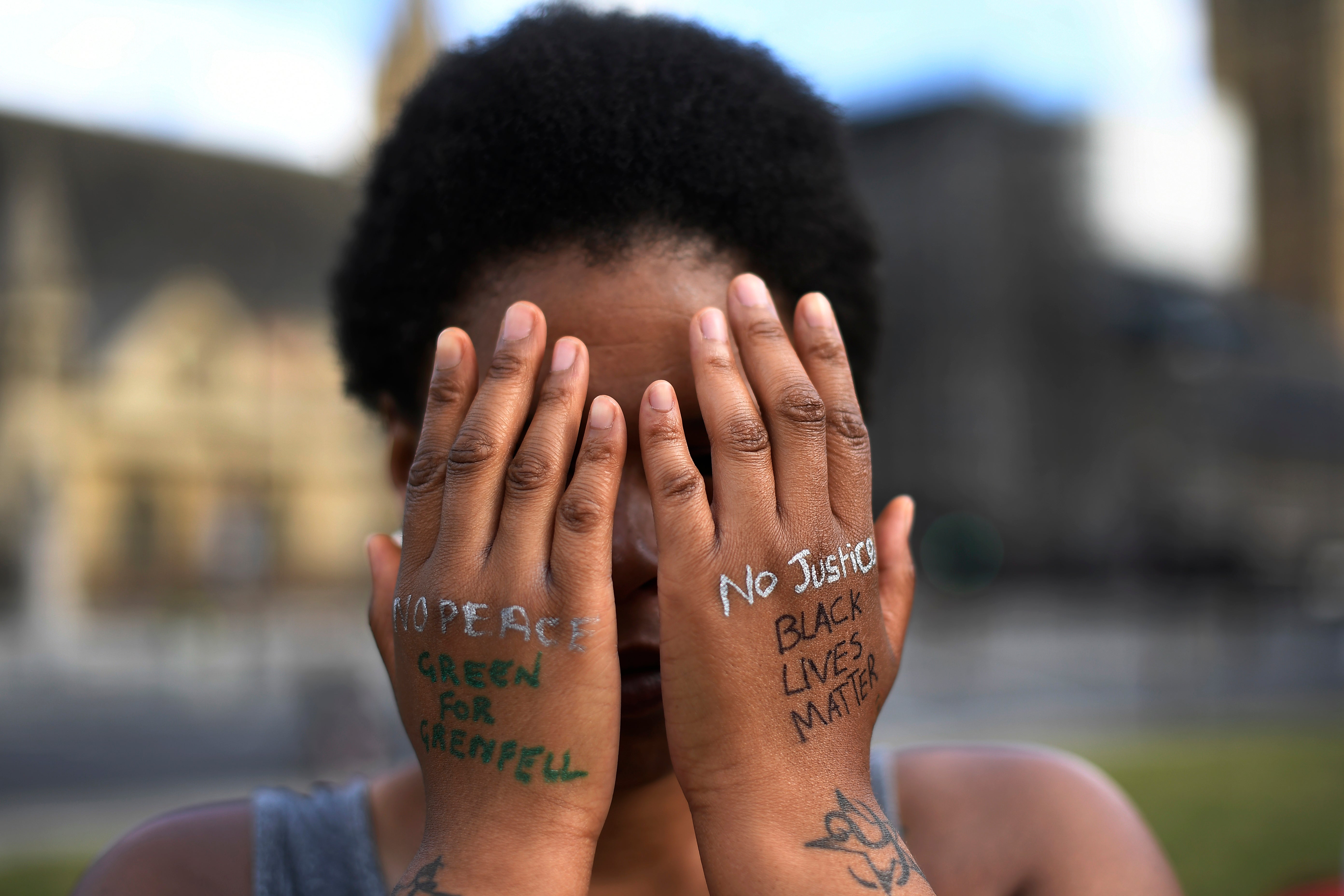 A woman symbolically covers her eyes as she participates in a Black Lives Matter protest in June 2020
