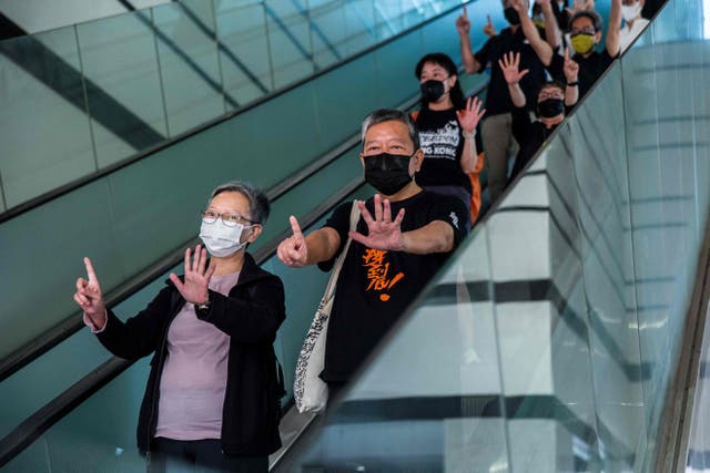 <p>Former lawmaker Cyd Ho (L) and pro-democracy activist Lee Cheuk-yan (C) gesture while leaving West Kowloon court in Hong Kong on 1 April, 2021, after being found guilty of organising an unauthorised assembly in August 2019</p>
