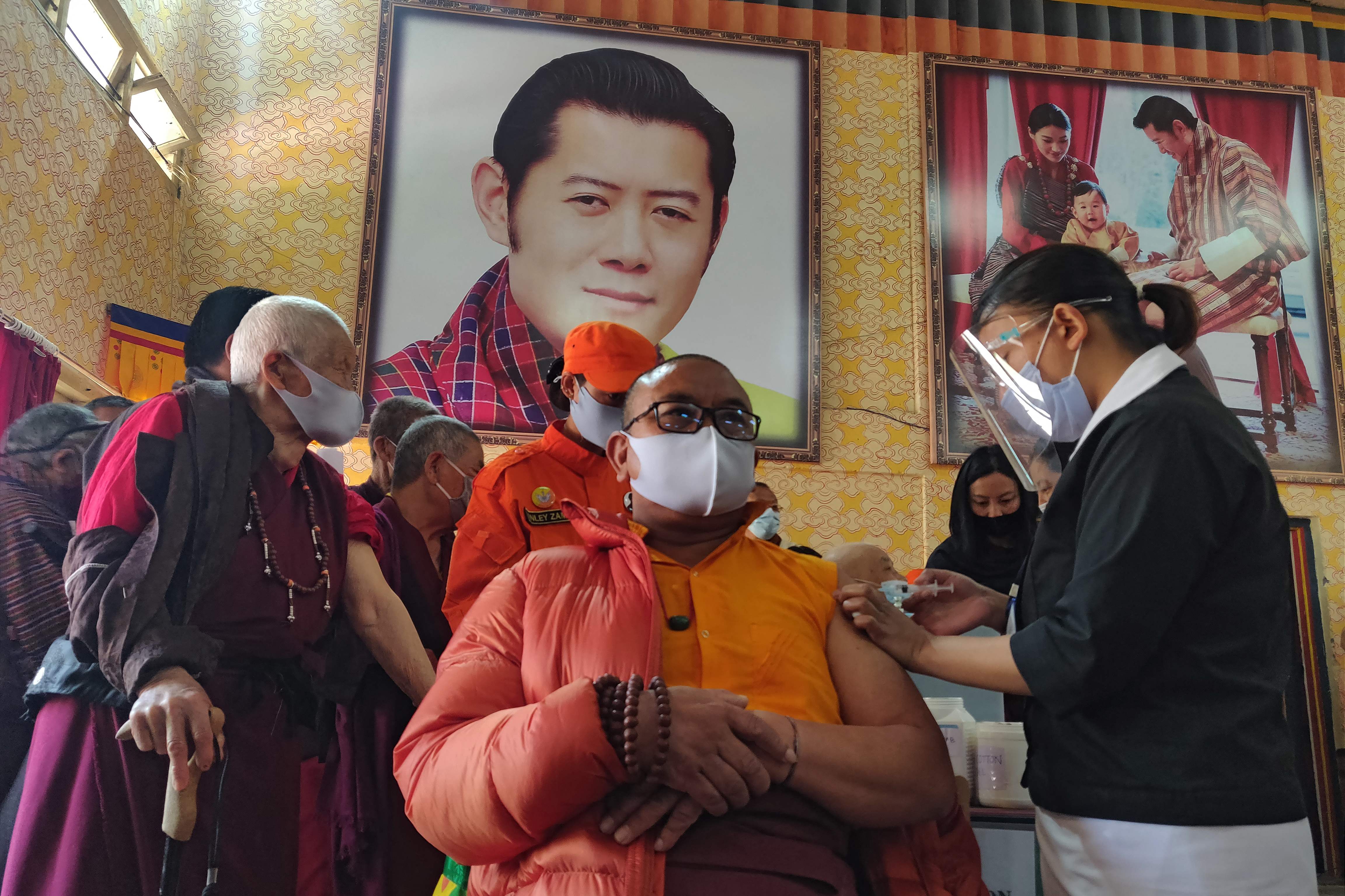 A health worker inoculates a Buddhist monk on the first day of vaccination in Bhutan.