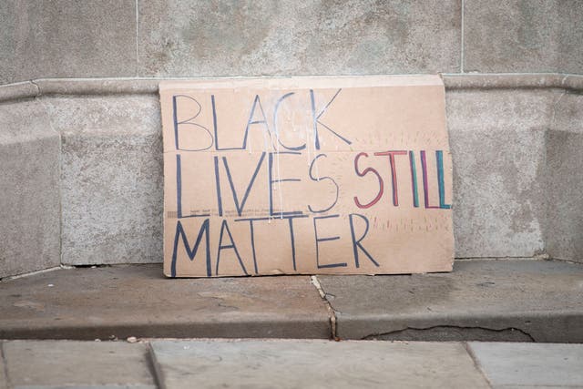 <p>BLM placard placed on the plinth of an Edward Colston statue in Bristol</p>
