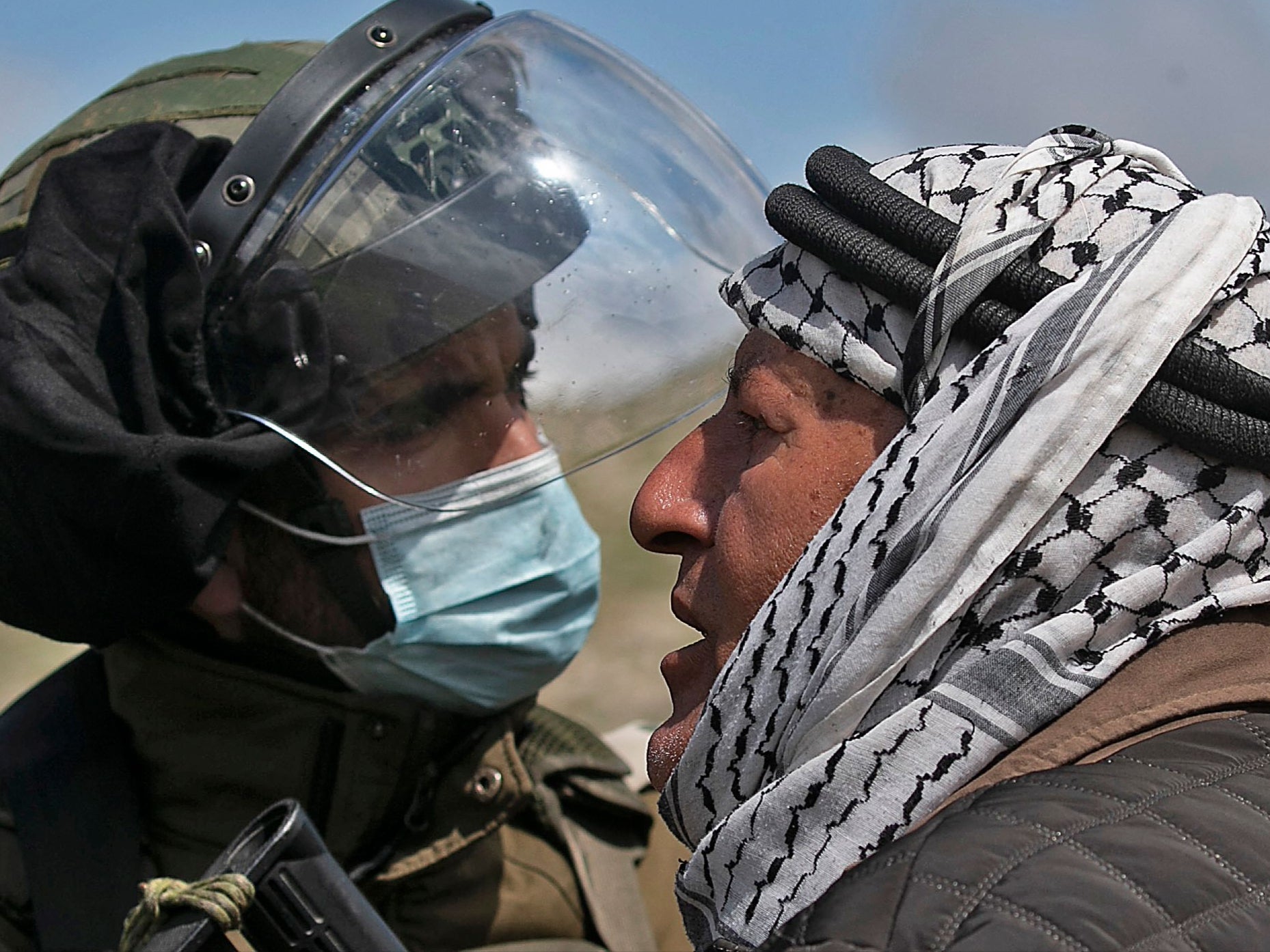 A Palestinian man and an Israeli soldier during a confrontation at a protest against the establishment of Israeli outposts in Palestinian lands at Beit Dajan, in the occupied West Bank, on 26 March