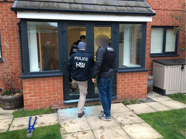 <p>Police entering a property as part of an investigation into a gang selling large quantities of ecstasy around the world on the dark web</p>
