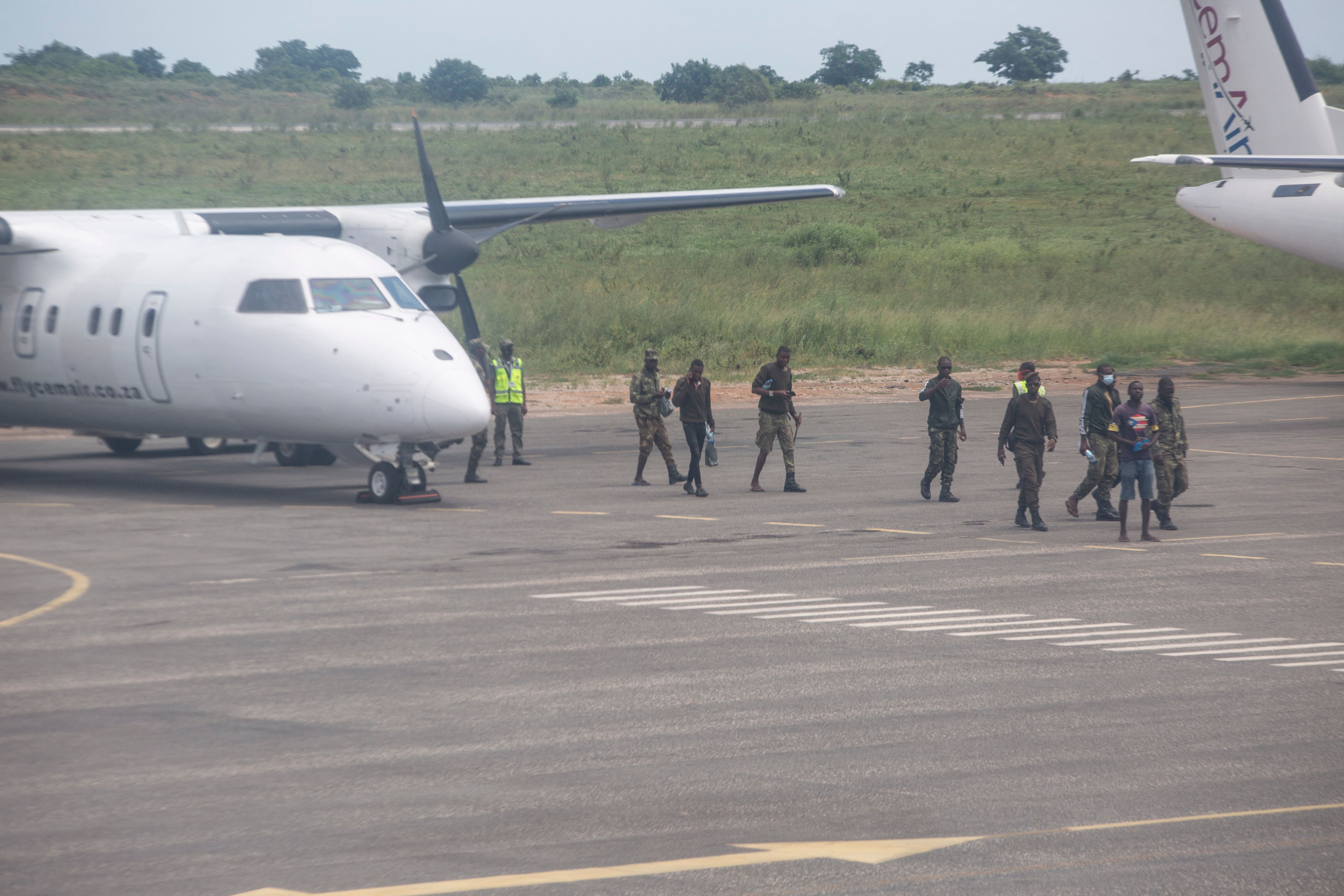 Mozambican soldiers are seen leaving a plane parked on the tarmac of the airport in Pemba on 31 March