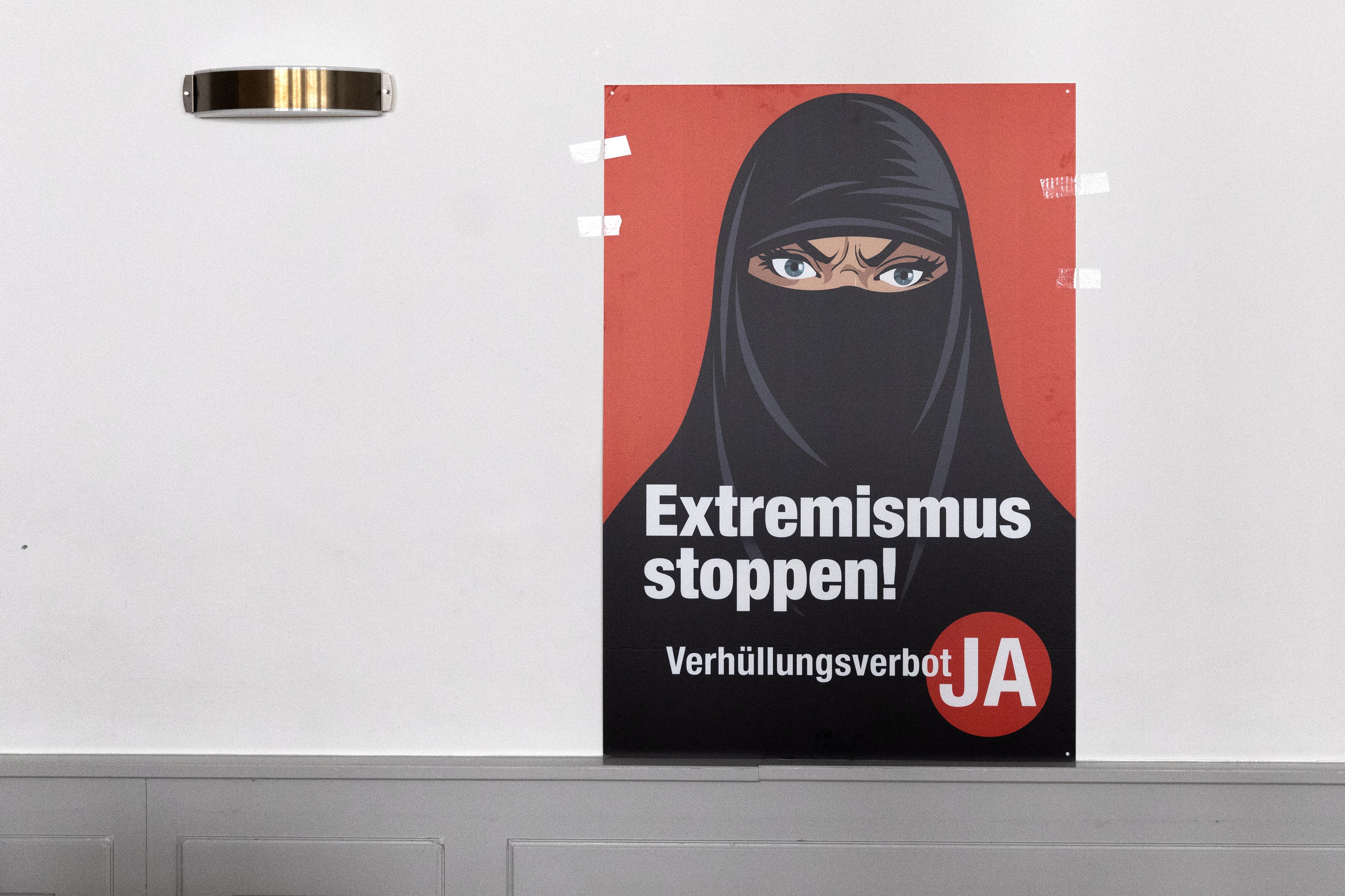 A poster saying 'Stop Extremism' hangs on a wall at the meeting place of the supporters of the burqa ban initiative, in Bern
