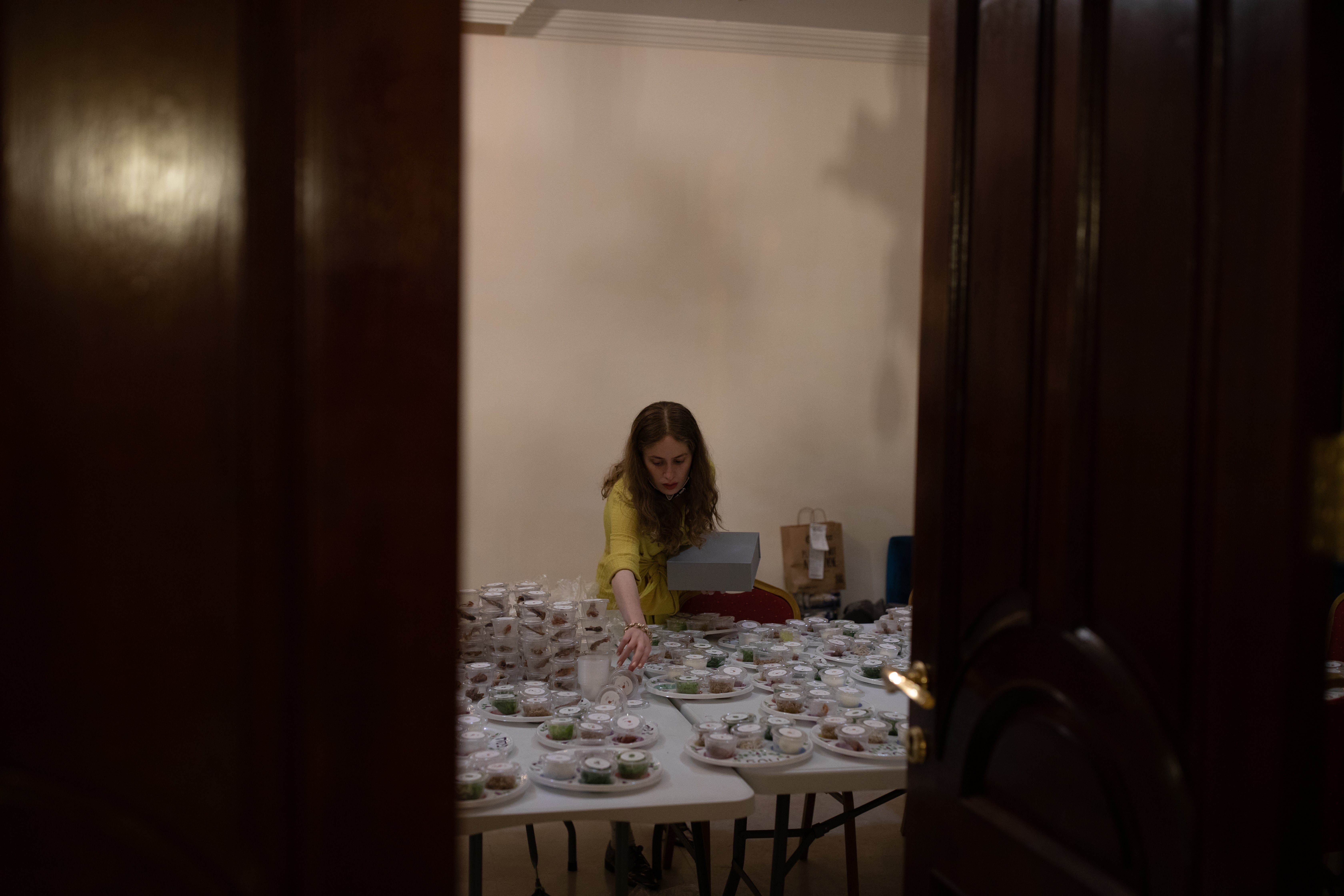 A woman at the Jewish Community Centre prepares Seder To Go boxes to serve community members staying at their homes for Passover