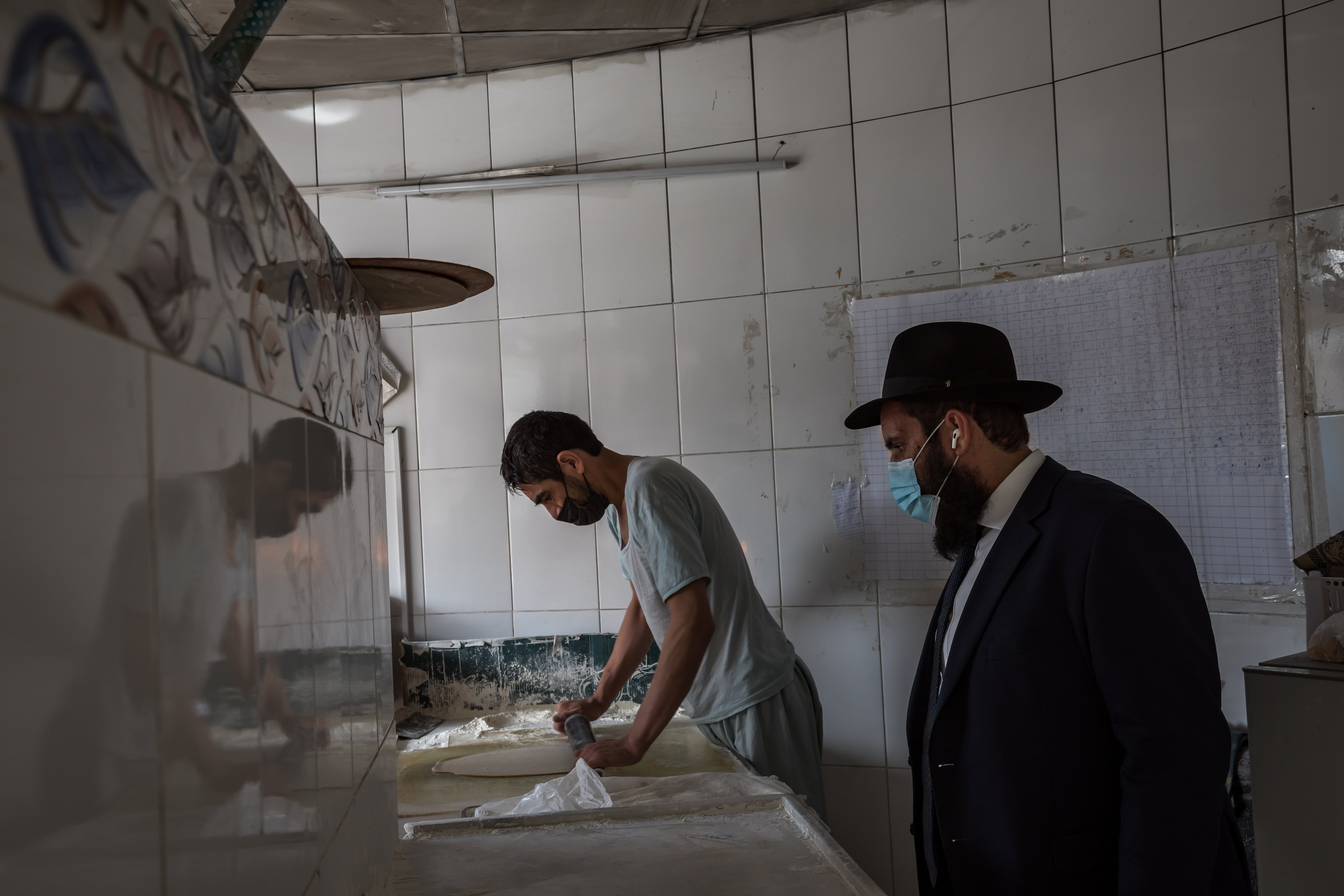 Rabbi Levi Duchman lites the flame to the oven and supervises the baking of bread at Raboa Satwa Bakery on March 22, 2021 in Dubai