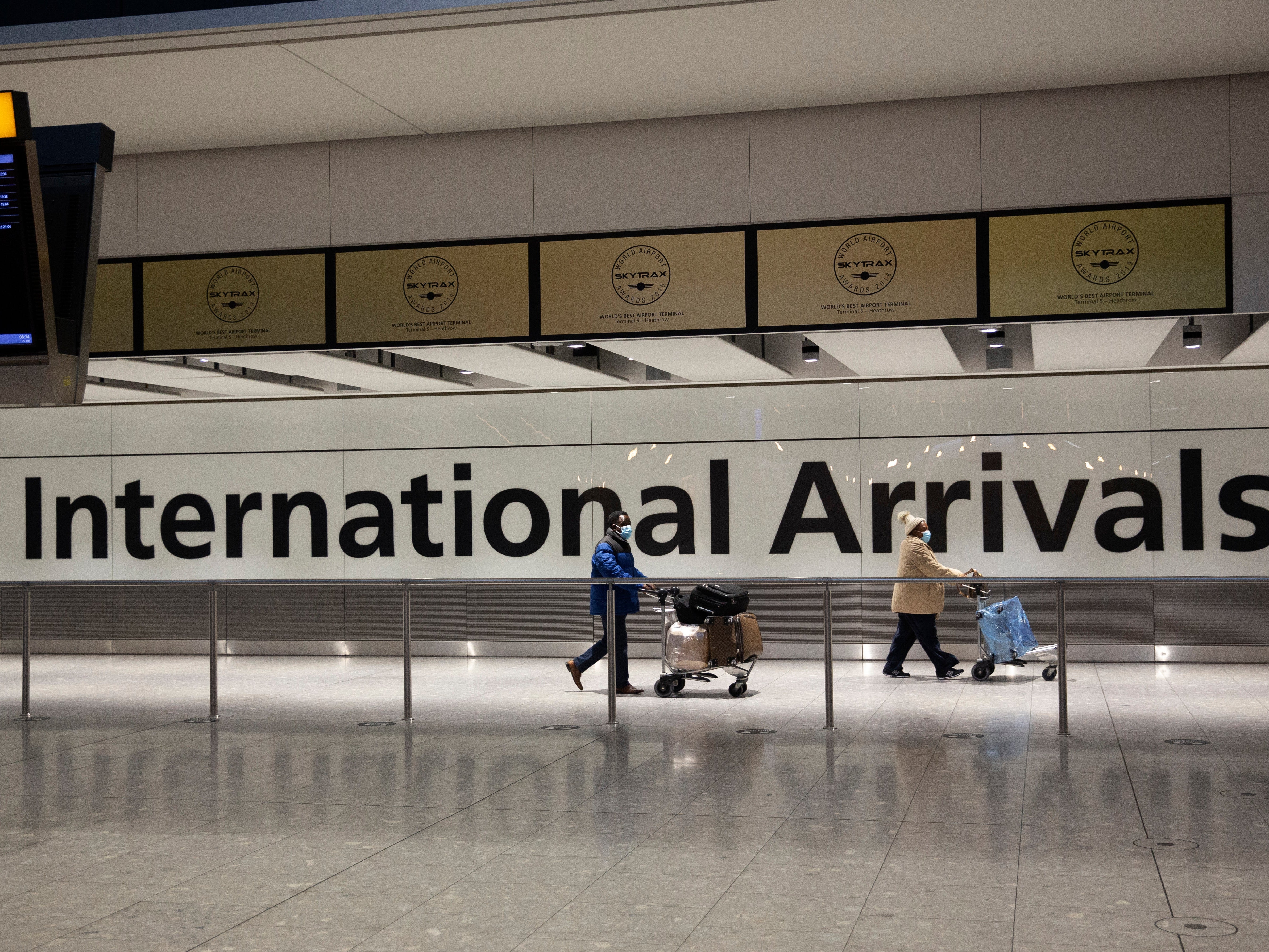 Arriving passengers walk past a sign in the arrivals area at Heathrow Airport in London in January during England’s third national lockdown
