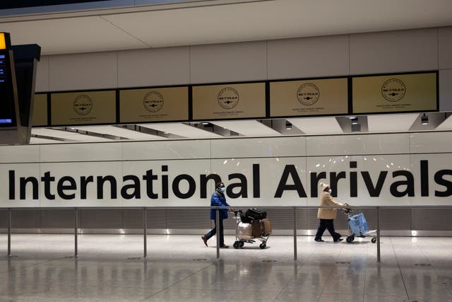 Arriving passengers walk past a sign in the arrivals area at Heathrow Airport in London in January during England’s third national lockdown