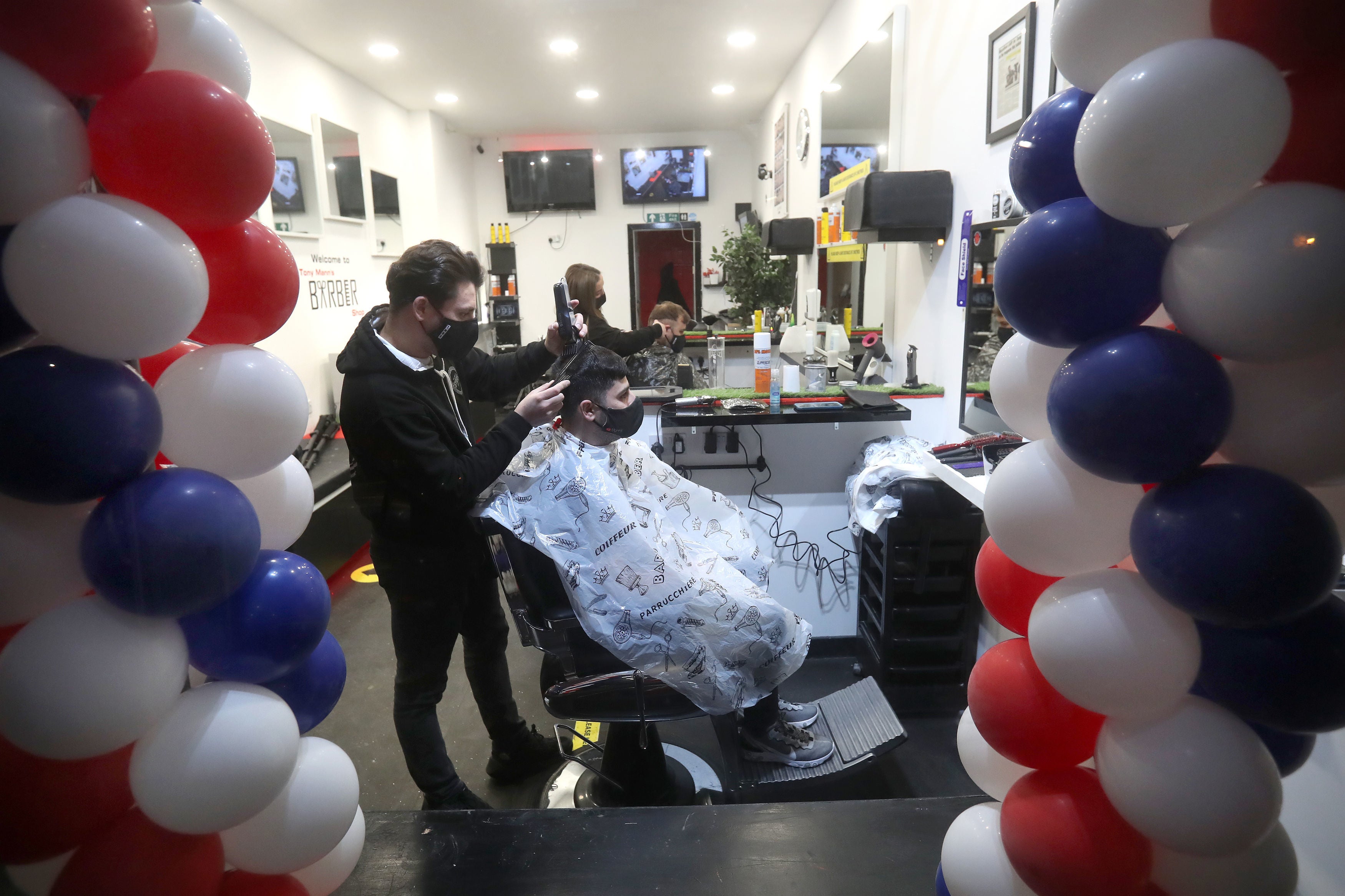 Barber Tony Mann trims Maxx Mann's hair at Tony Mann's Barber Shop in Giffnock