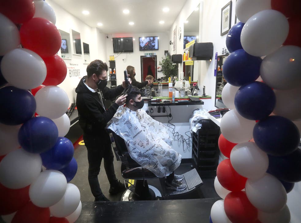 <p>Barber Tony Mann trims Max Mann's hair at Tony Mann's Barber Shop in Giffnock</p>