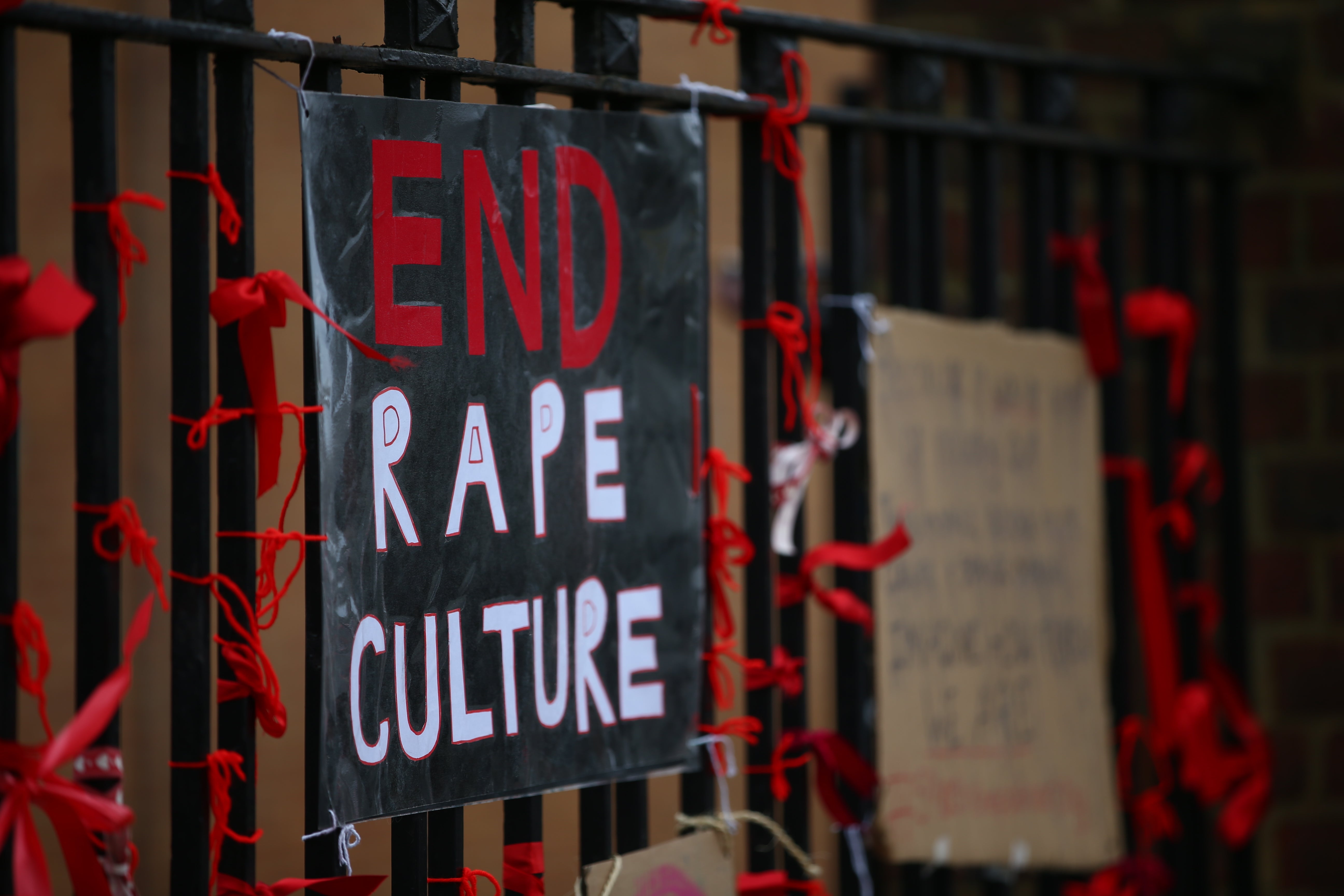 A placard saying 'End Rape Culture' attached to the fence outside James Allen's Girls' School in London