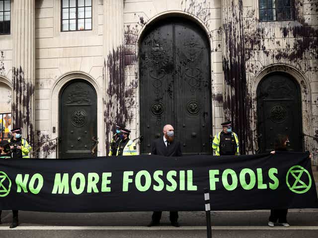 Activists dressed in suits and hi vis clothing protest outside the Bank of England on 1 April