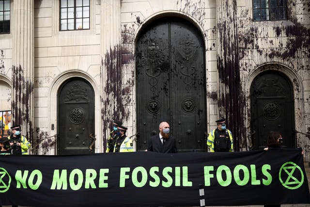 Activists dressed in suits and hi vis clothing protest outside the Bank of England on 1 April