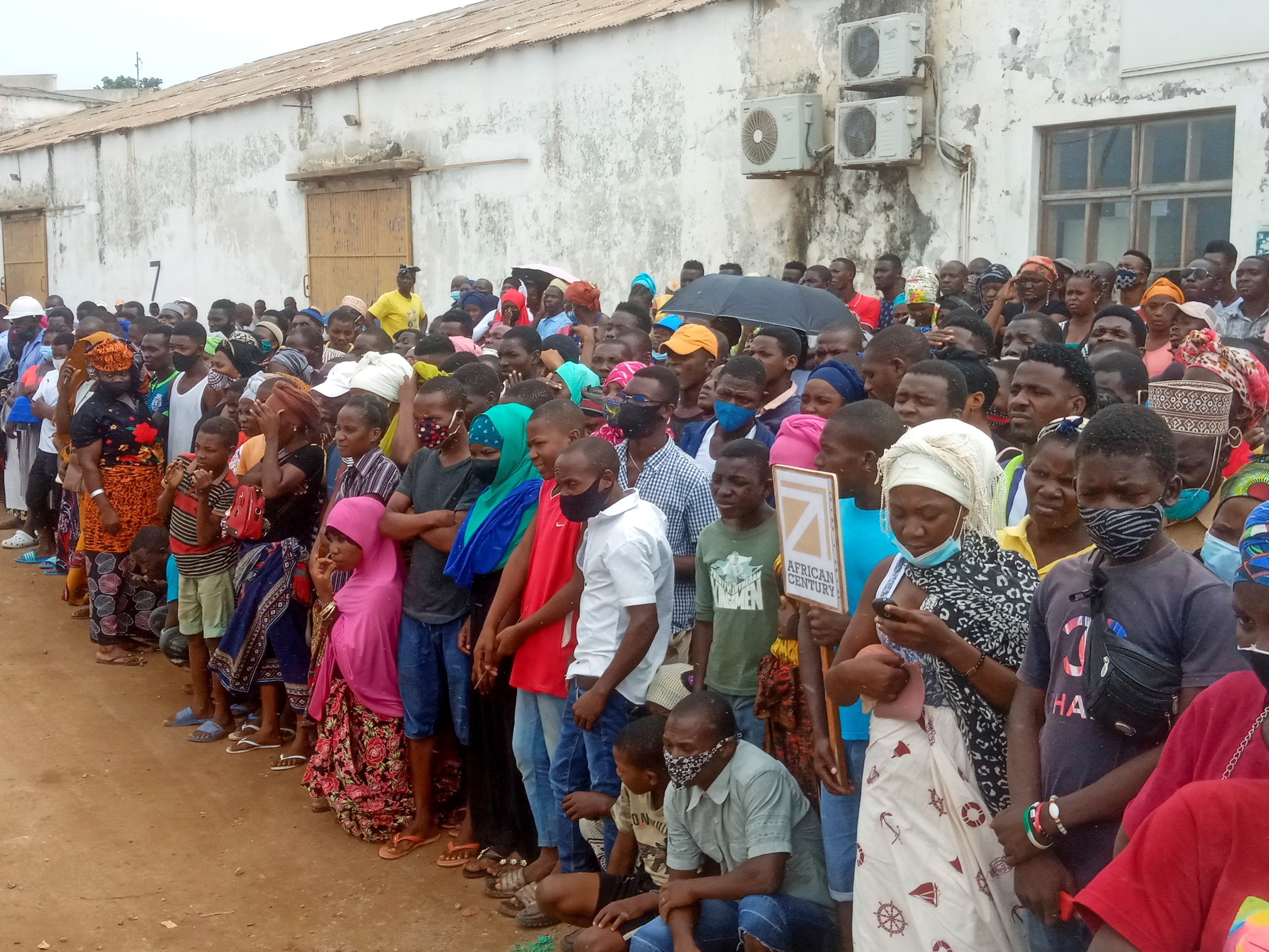 People wait for friends and relatives as a ship carrying more than 1,000 people fleeing an attack claimed by Isis-linked insurgents on the town of Palma, docks in Pemba, Mozambique