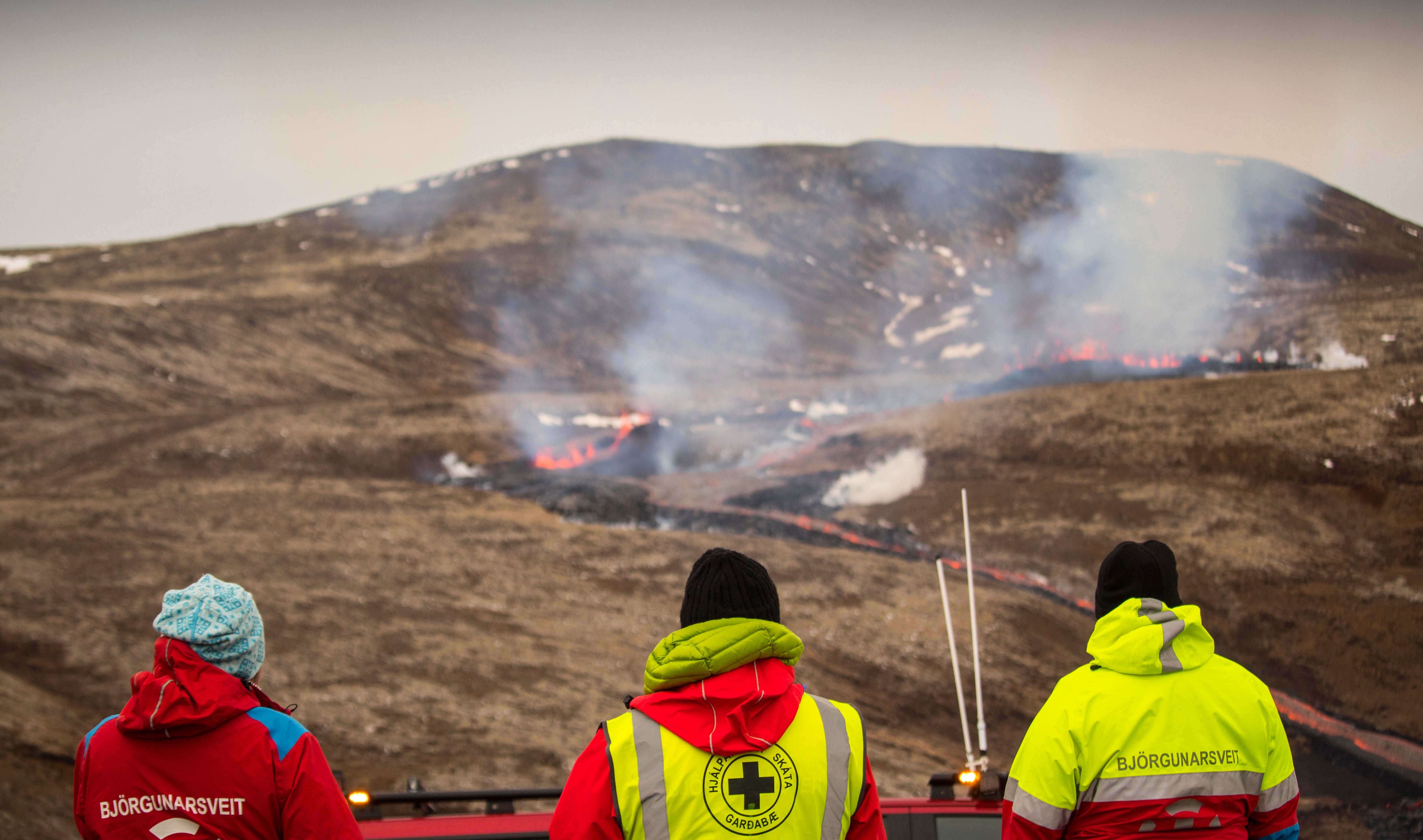 Members of the Search and Rescue Team, Bjorgunasveit look at a new fissure on a volcano