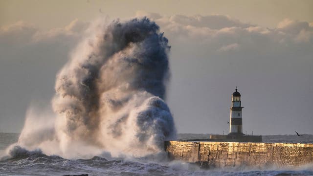 Waves crash over the walls next to Seaham Lighthouse in Durham