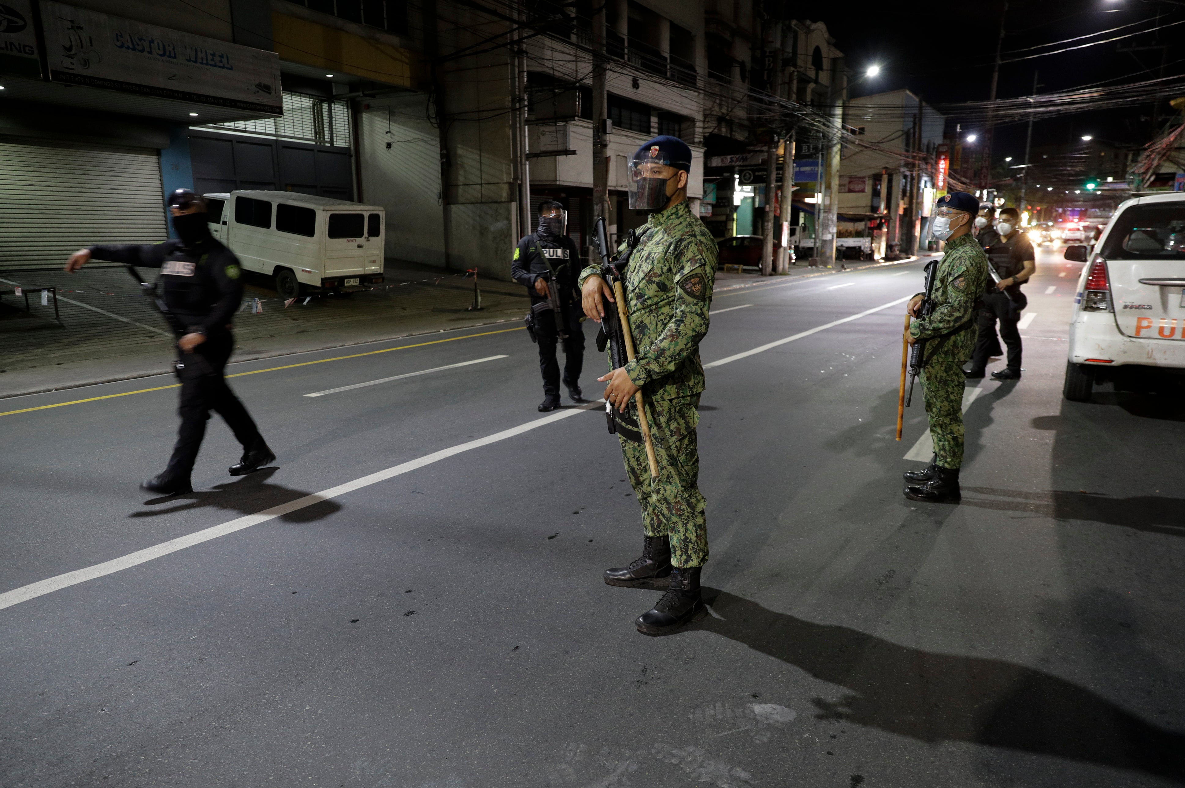 Armed policemen patrol the streets as curfew is imposed in metro Manila, Philippines, on 15 March, 2021