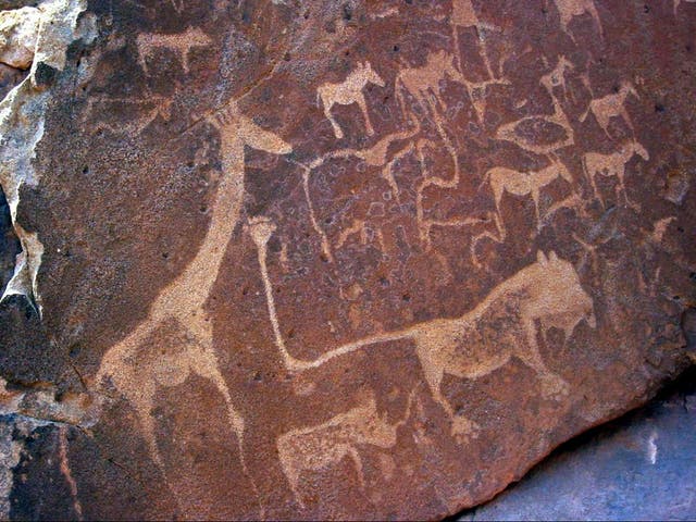 Ancient rock engravings at Twyfelfontein in Namibia depicting large mammals including giraffe and lions