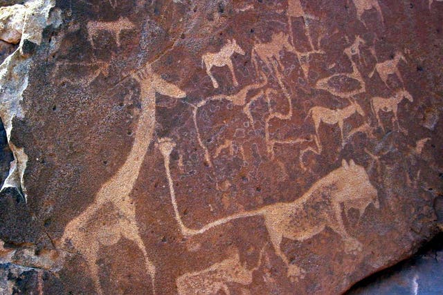Ancient rock engravings at Twyfelfontein in Namibia depicting large mammals including giraffe and lions