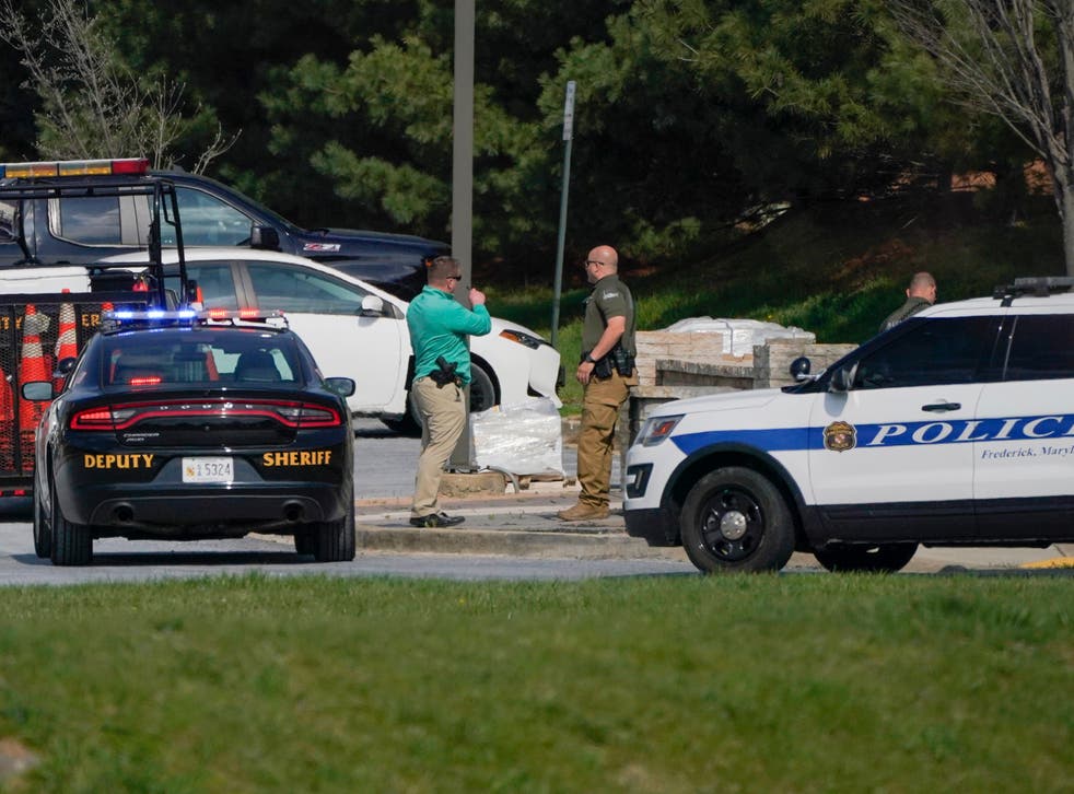 <p>Police talk near the scene of a shooting at a business park in Frederick, Maryland, Tuesday, 6 April, 2021</p>