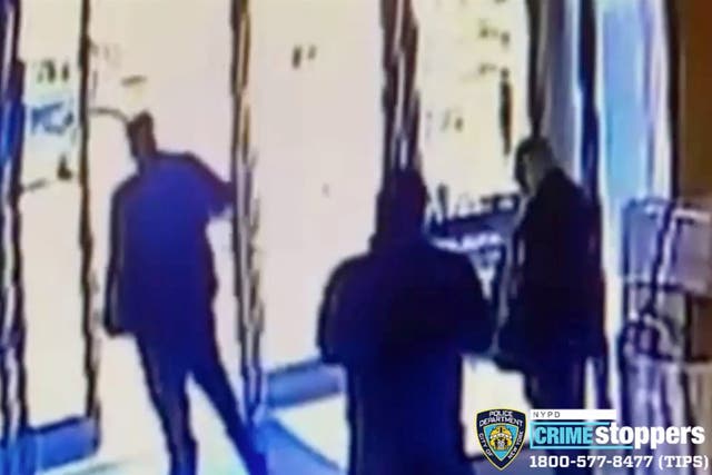 Two doormen watch as an Asian woman is beaten outside a New York luxury apartment building