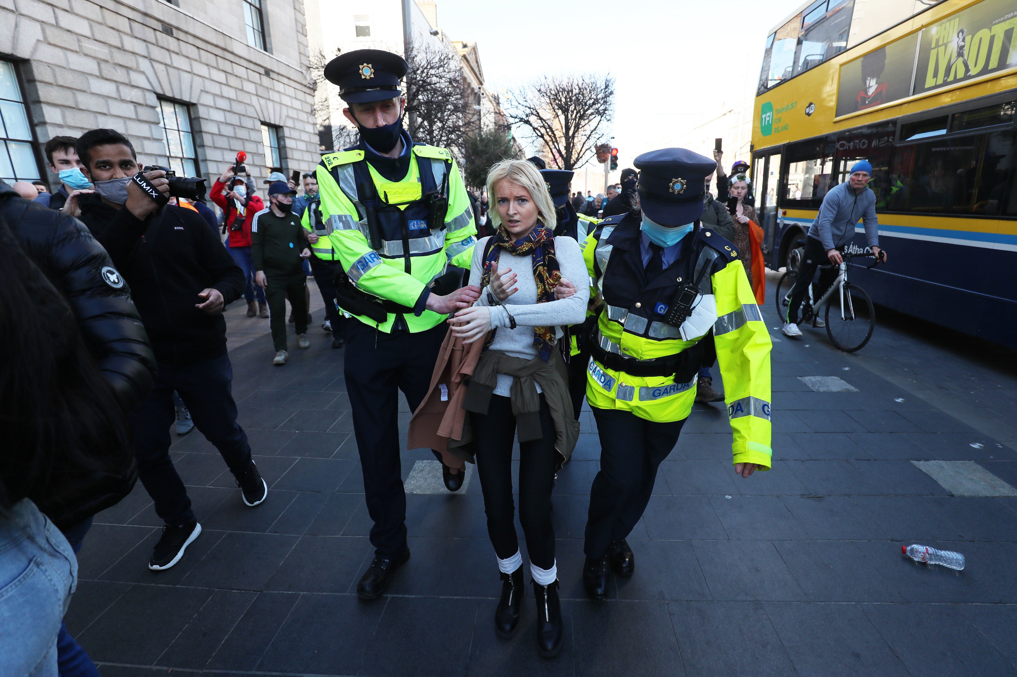 Irish police arrest a woman on O’Connell Street in Dublin city centre ahead of a planned anti-lockdown protest in March