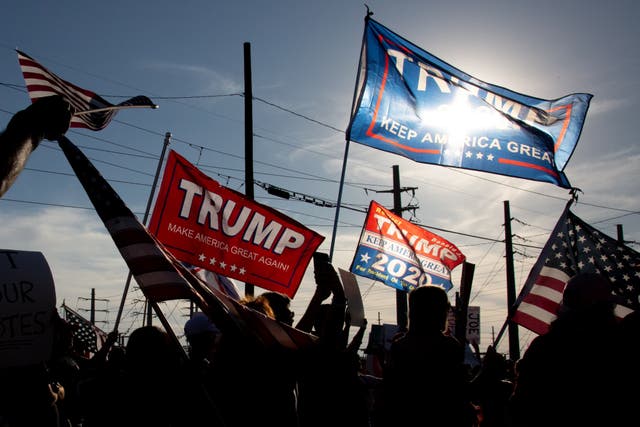 <p>Supporters of President Donald Trump wave flags to protest the election results at the Maricopa County Elections Department office on November 5, 2020 in Phoenix, Arizona</p>