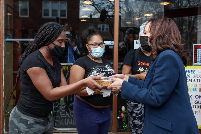 <p>US Vice President Kamala Harris (R) receives a piece of German Chocolate Cake from workers outside of the Brown Sugar Bakery during a quick stop in Chicago, Illinois, on April 6, 2021</p>