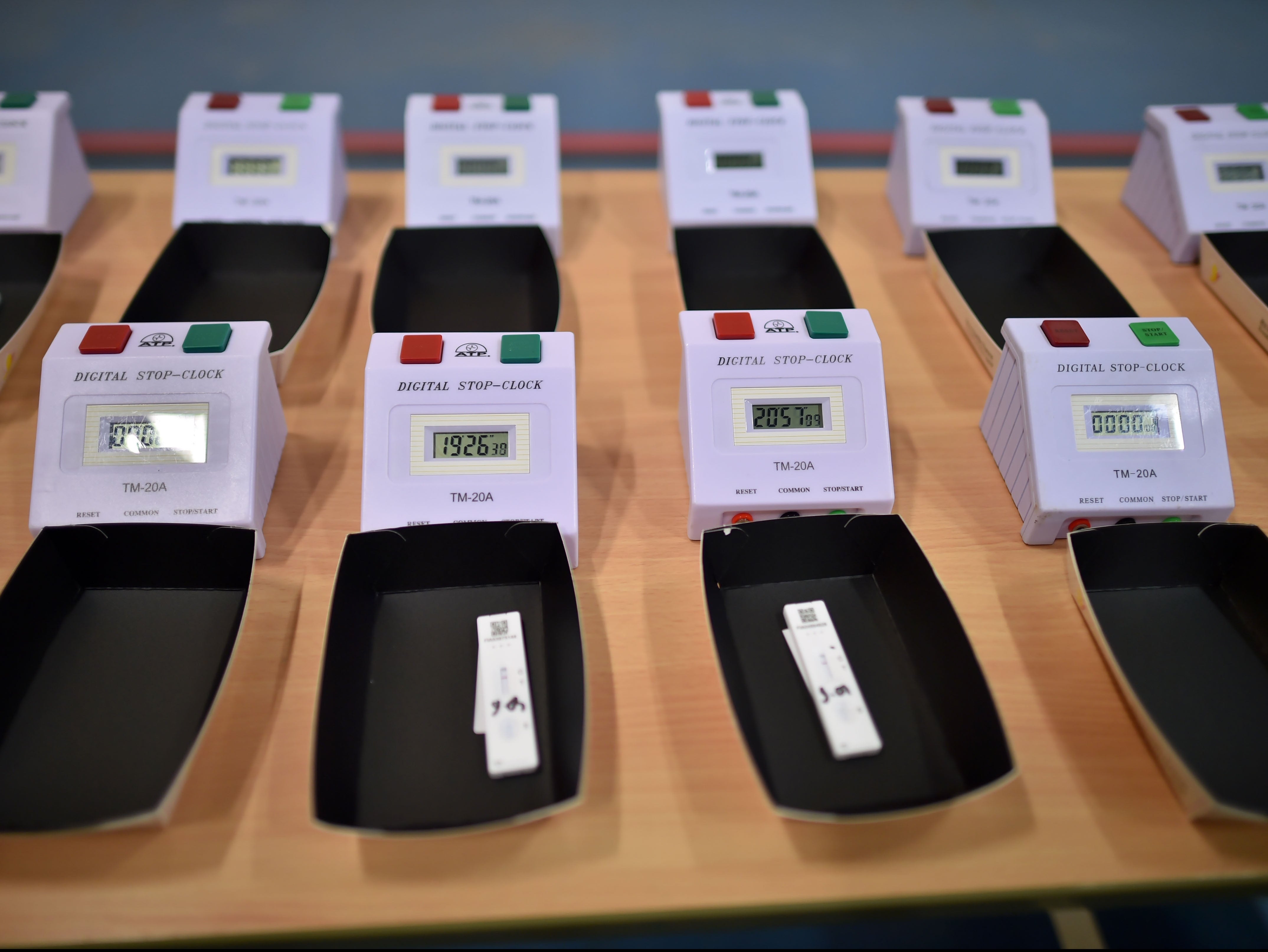 Individual school pupil's lateral flow tests sit next to electronic timers, awaiting accurate results, at Archway School in Stroud in Gloucestershire