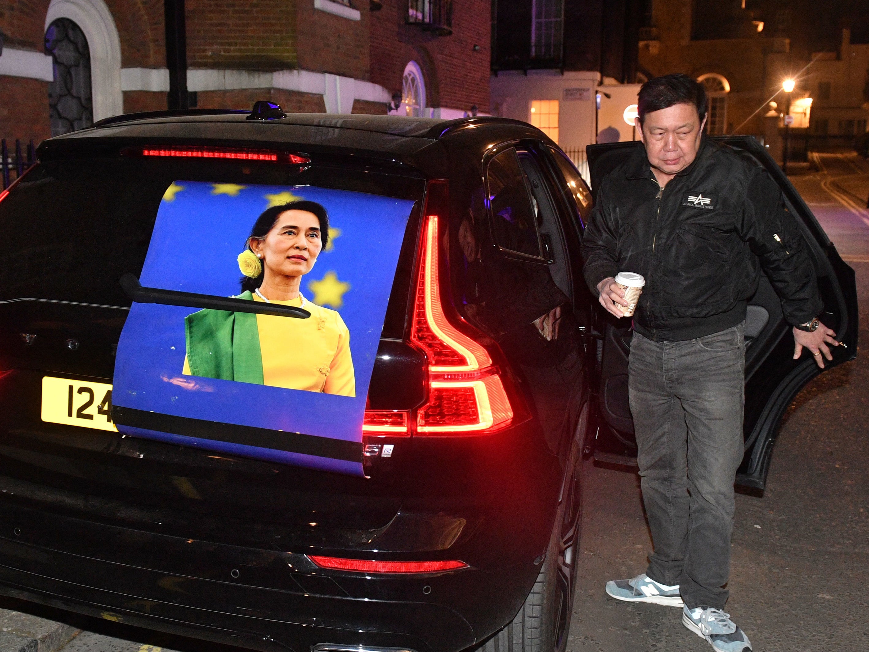 Kyaw Zwar Minn got out of a car bearing a large image of Aung San Suu Kyi