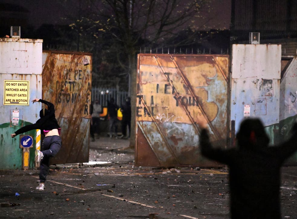 Youths exchange projectiles through the Peace Gate on Wednesday