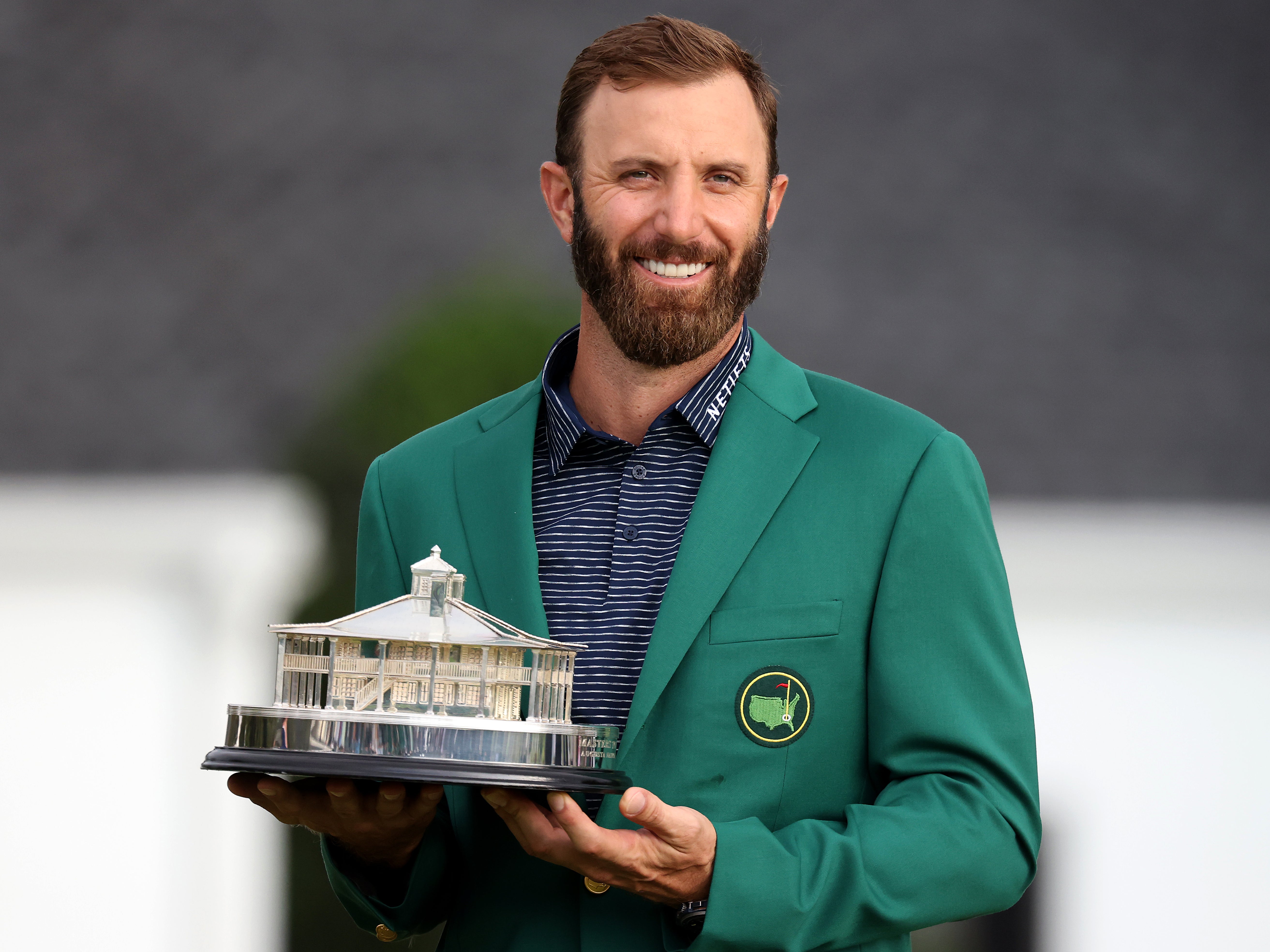 Dustin Johnson poses with the trophy at August in 2020