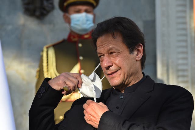 <p>Pakistan's Prime Minister Imran Khan removes his face mask during a joint press conference with Afghan President Ashraf Ghani (not pictured) at the Presidential Palace in Kabul on 19 November, 2020. </p>