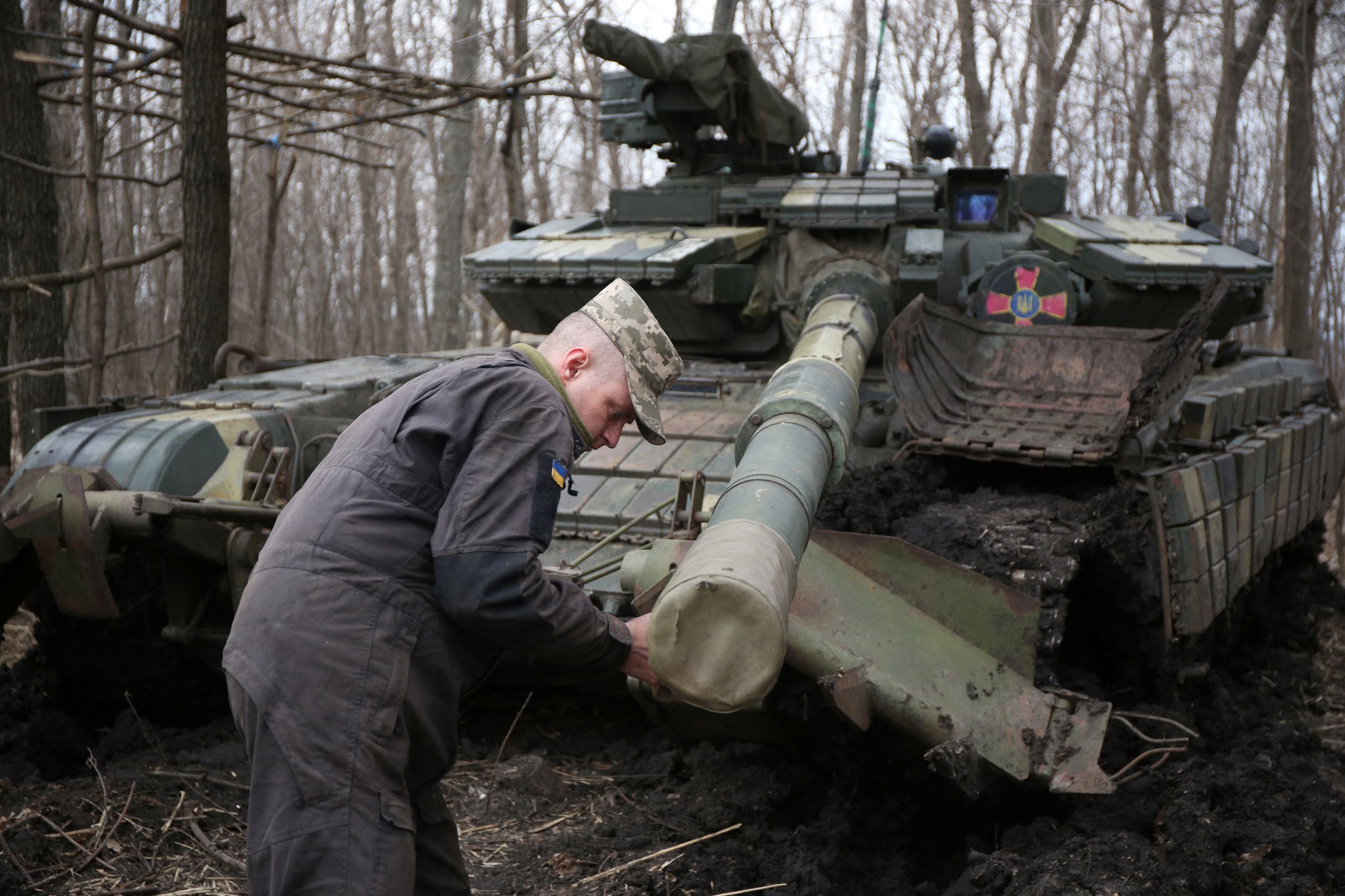 A Ukraine soldier works on his tank, in the Lugansk region, not far from the front line with Russia-backed separatist forces