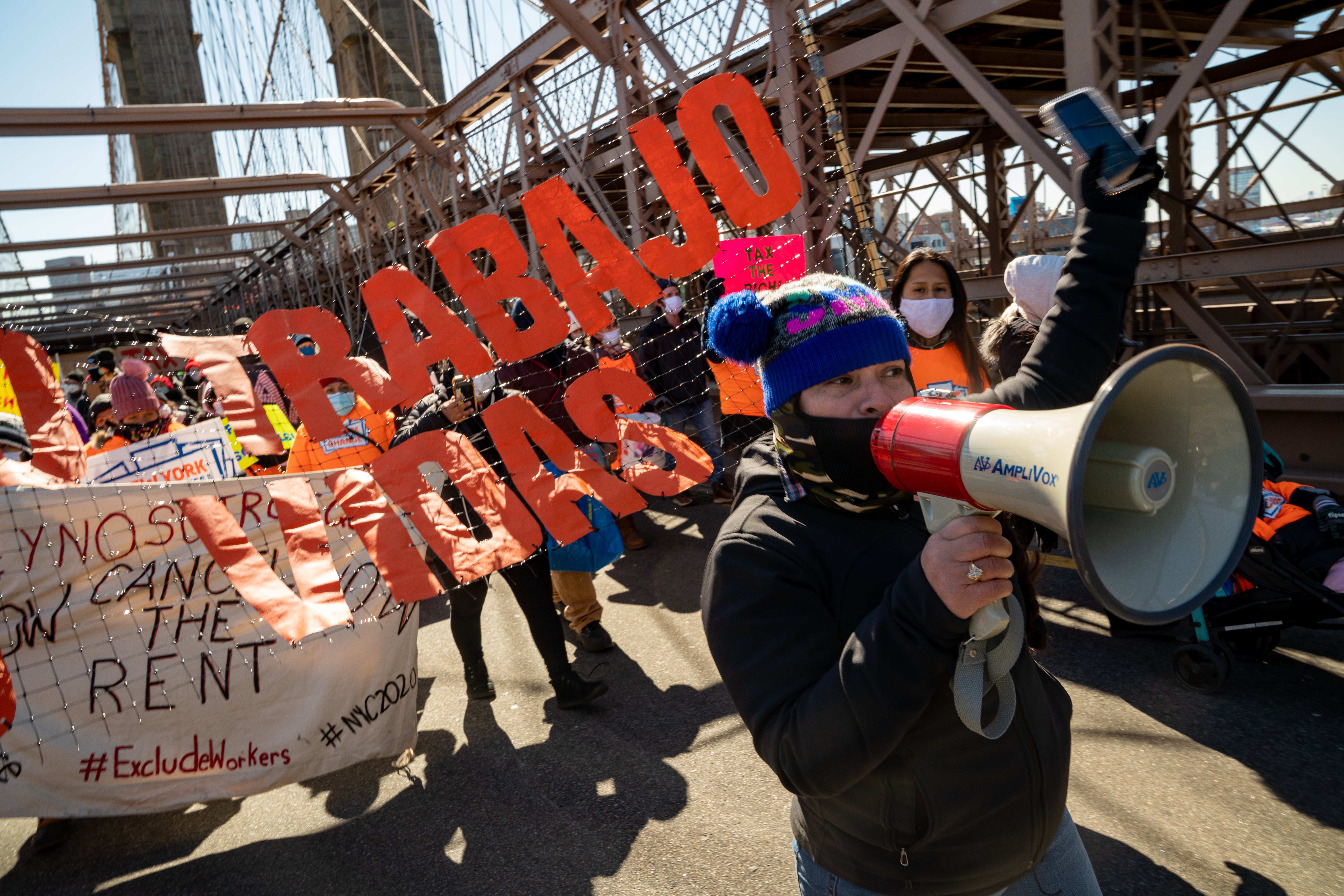 Protestors march across the Brooklyn Bridge to demand funding for excluded workers in the New York State budget on 5 March 2021