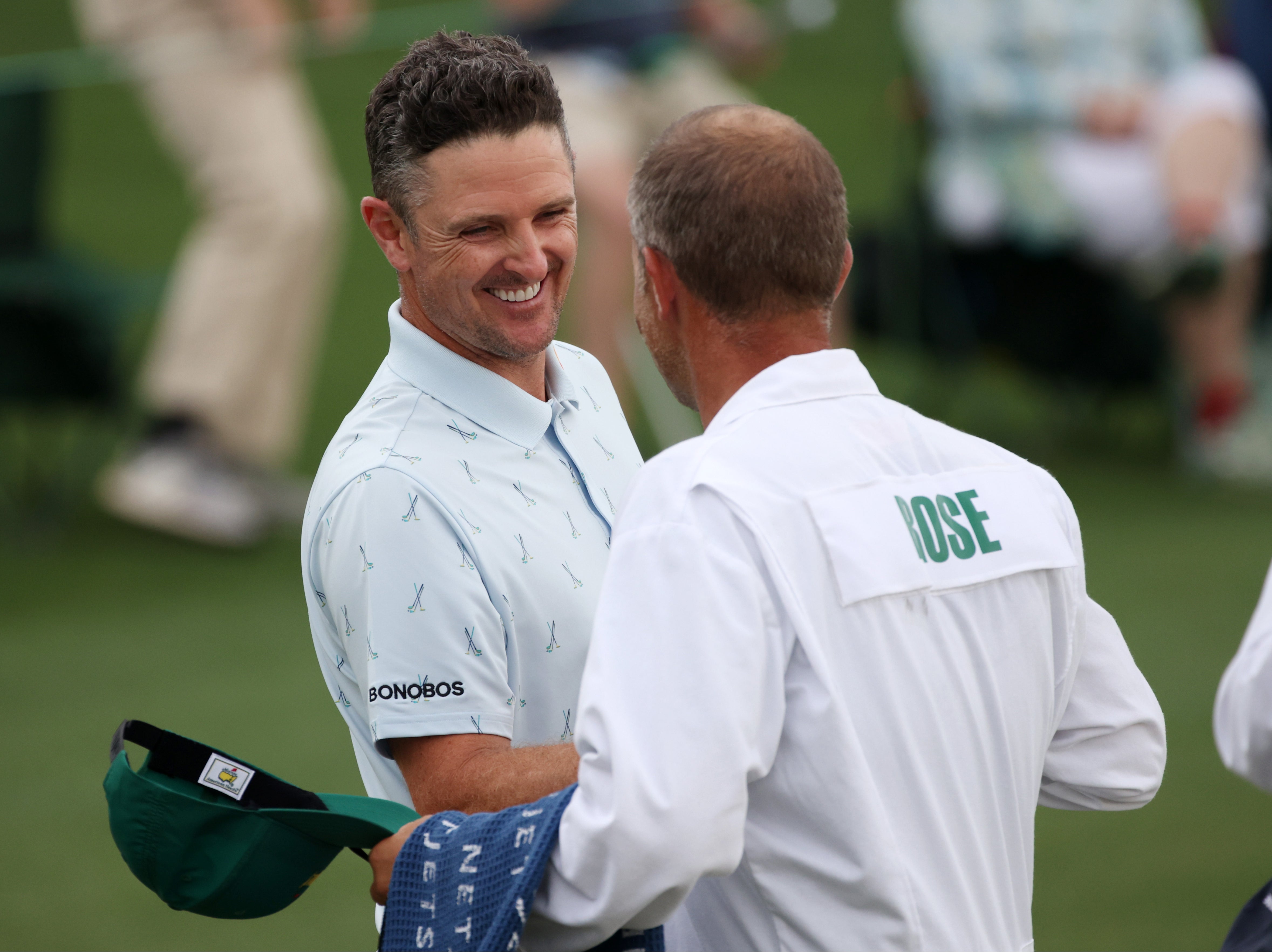 Justin Rose of England fist bumps his caddie, David Clark