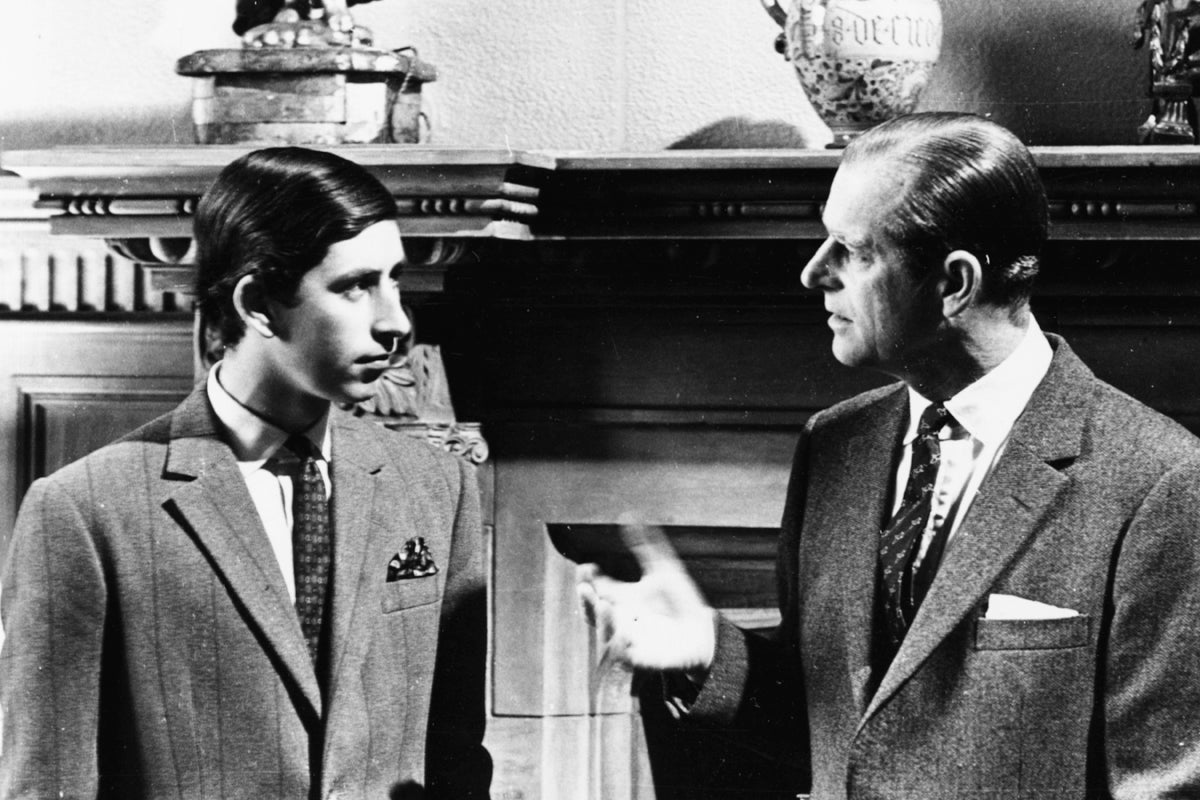 1969: Prince Charles (left) talking to his father, the Duke of Edinburgh, in front of a fireplace at Sandringham, Scotland, 1969