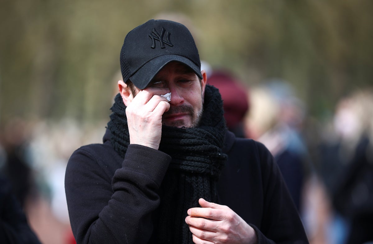 A mourner cries outside Buckingham Palace