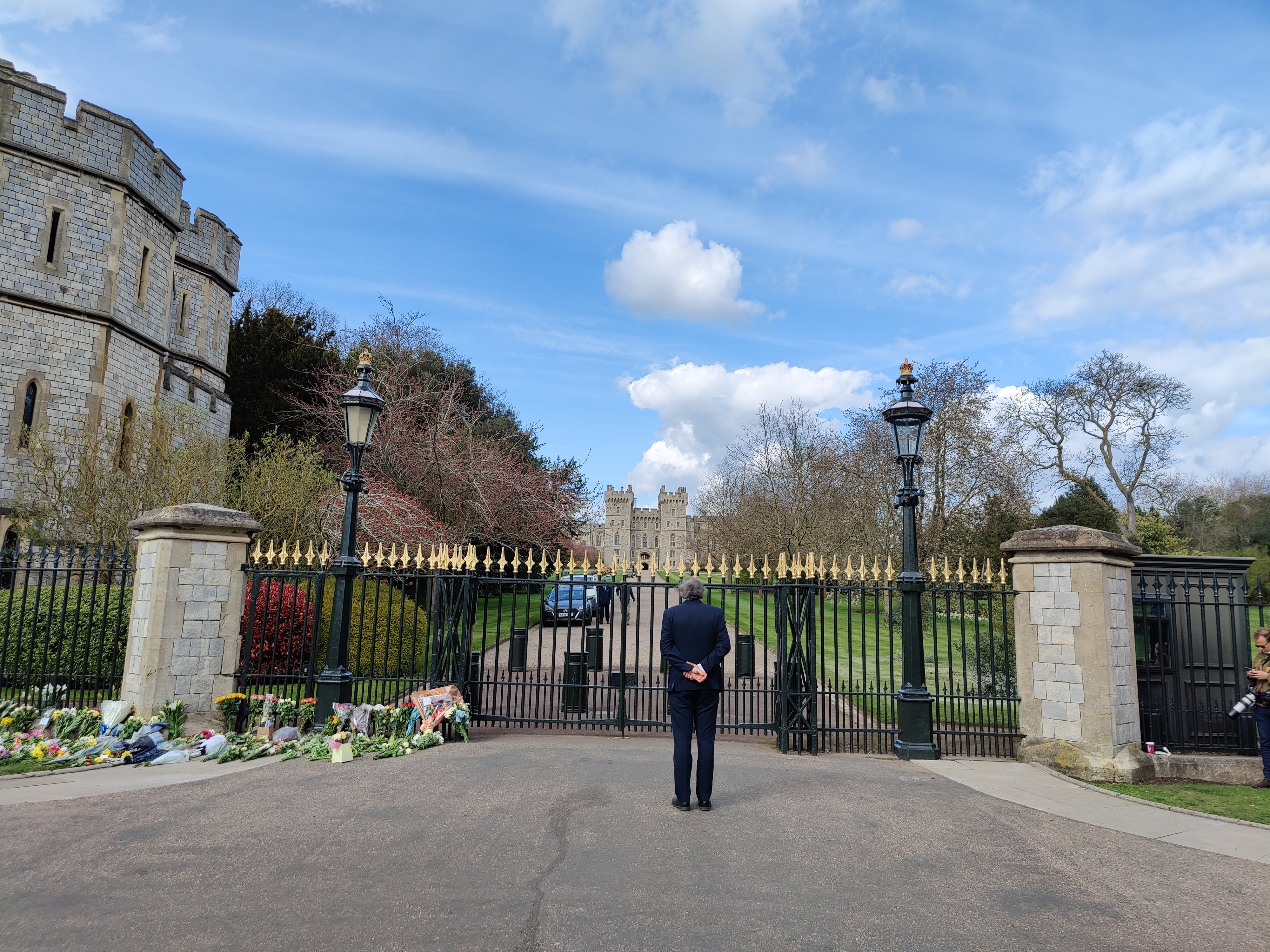 A man stands in front of the gate to Windsor Castle to pay his respects to Prince Philip