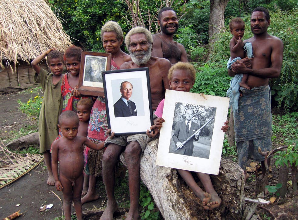 Villagers on the island of Tanna hold up treasured photos of Prince Philip