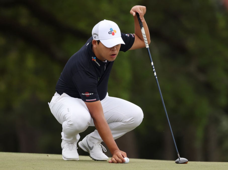 Si Woo Kim lines up a putt with his three-wood