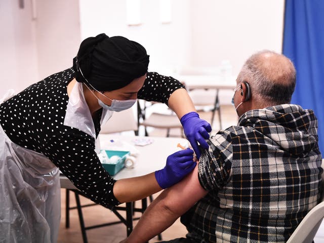 A person receives the AstraZeneca vaccine in Derby, England